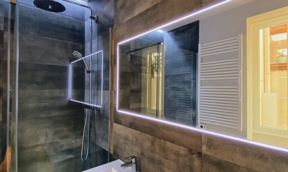 baño baño con plato de ducha y un gran espejo rectangular.